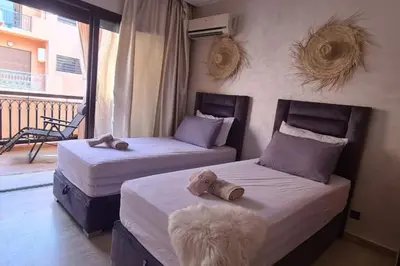 two beds in a room with a balcony at appartement 2 chambres en plein centre ville gueliz marrakech in Marrakech