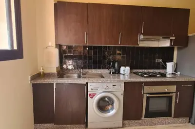 a kitchen with a washing machine and a stove at appartement 2 chambres en plein centre ville gueliz marrakech in Marrakech
