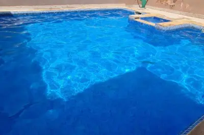 a large swimming pool with blue water at appartement 2 chambres en plein centre ville gueliz marrakech in Marrakech
