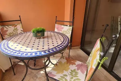 a table and two chairs with a plant on it at appartement 2 chambres en plein centre ville gueliz marrakech in Marrakech