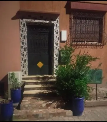 a front door of a building with stairs and plants at Dar ALBIDAWI in Marrakech