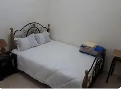 a bed with white sheets and pillows in a bedroom at Dar ALBIDAWI in Marrakech