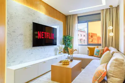 a living room with a couch and a tv on a wall at Sérénité Tranquille Au Cœur du Centre Ville in Marrakech