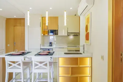 a kitchen with white counters and white stools at Sérénité Tranquille Au Cœur du Centre Ville in Marrakech
