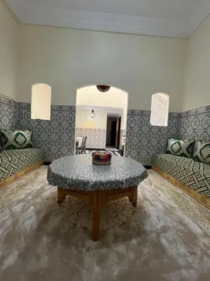 a living room with a table and a couch at Amazing 3 Bedroom Riad Marrakech in Marrakech