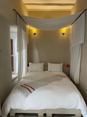 a bedroom with a large bed with white sheets at Riad Dar one in Marrakech
