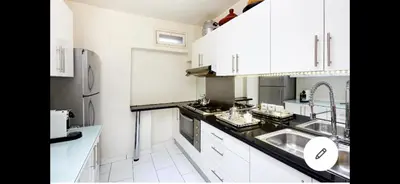a white kitchen with a sink and a refrigerator at Riad Dar one in Marrakech
