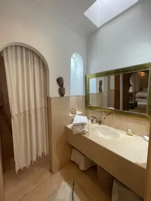 a bathroom with a sink and a shower with a mirror at Riad Dar one in Marrakech