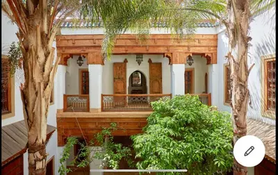 a house with a porch with trees in front of it at Riad Dar one in Marrakech
