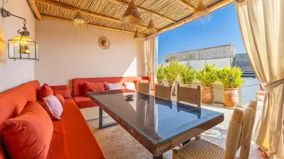 a living room with a red couch and a table at Riad Jarco Marrakech, cœur Medina, Rooftop, bassin , Proche Place Jemaa el fna in Marrakech