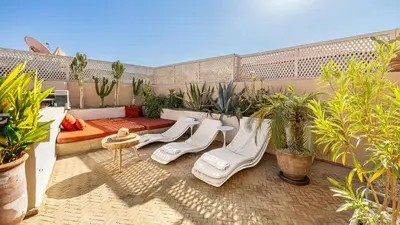 a patio with white furniture and plants on a balcony at Riad Jarco Marrakech, cœur Medina, Rooftop, bassin , Proche Place Jemaa el fna in Marrakech