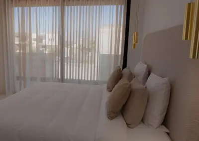 a bedroom with a white bed with pillows and a window at Villa Volubilis - Marrakech in Marrakech