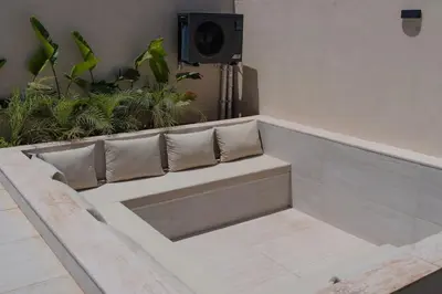 a bench with pillows sitting in a room with plants at Villa Volubilis - Marrakech in Marrakech