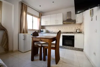 a kitchen with a wooden table and chairs in it at Studio chic cosy au centre de l'hivernage marrakech in Marrakech