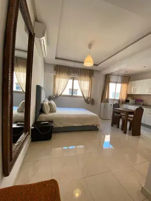 a bedroom with a bed with a mirror and a table at Studio chic cosy au centre de l'hivernage marrakech in Marrakech