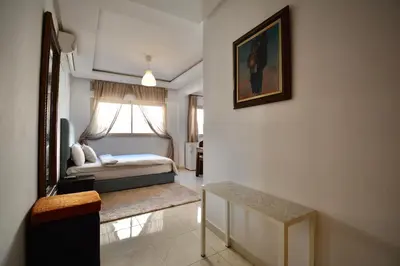 a bedroom with a bed and a window and a table at Studio chic cosy au centre de l'hivernage marrakech in Marrakech