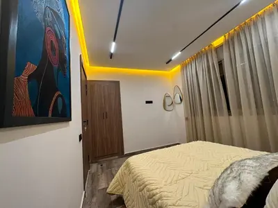 a bedroom with a bed and a painting on the wall at Élégant Appartement Moderne familiale Marrakech in Marrakech