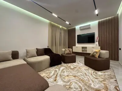 a living room with a couch and a flat screen tv at Élégant Appartement Moderne familiale Marrakech in Marrakech
