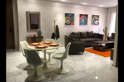 a living room with a table and chairs and a couch at Appartement neuf et cosy au coeur de Guéliz in Marrakech