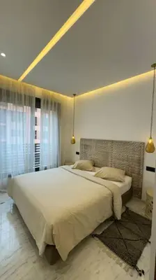 a bedroom with a large white bed with two pillows at Appartement neuf et cosy au coeur de Guéliz in Marrakech