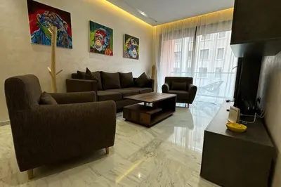 a living room with a couch and a tv at Appartement neuf et cosy au coeur de Guéliz in Marrakech