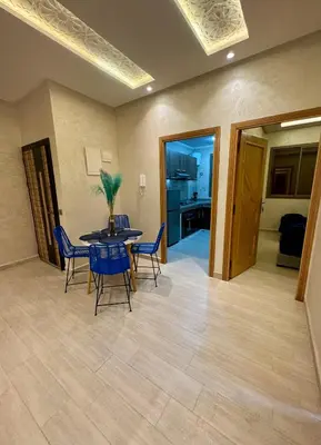 a dining room with a table and chairs and a kitchen at The Blue Pearl - Fresh & Modern in Marrakech