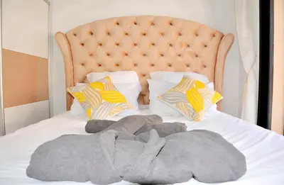 a bed with a blanket and pillows on it at L'Oasis Lumineux avec Piscine et Terrasse in Marrakech