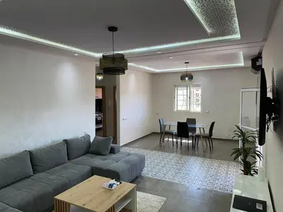 a living room with a couch and a table at Gorgeous newly renovated apt- Near Restaurant and Shopping Center in Marrakech