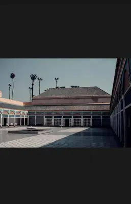 a large building with palm trees in the background at Gorgeous newly renovated apt- Near Restaurant and Shopping Center in Marrakech