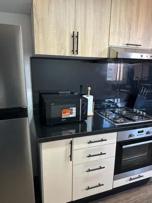 a kitchen with a microwave and a stove top oven at Gorgeous newly renovated apt- Near Restaurant and Shopping Center in Marrakech
