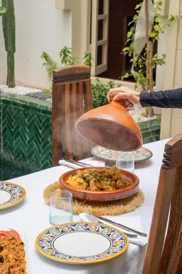a table with a plate of food on it at Riad EYNA Marrakech Medina in Marrakech