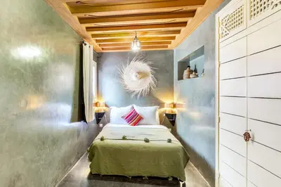 a small bedroom with a bed and two lamps at Riad EYNA Marrakech Medina in Marrakech