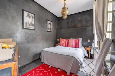 a bedroom with a large bed with red pillows at Riad EYNA Marrakech Medina in Marrakech