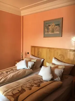 two beds in a room with orange walls at Appartement Elias Marrakech in Marrakech