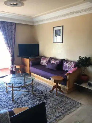 a living room with a purple couch and a table at Appartement Elias Marrakech in Marrakech