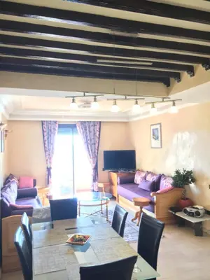 a living room with a table and a couch at Appartement Elias Marrakech in Marrakech