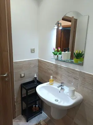 a bathroom with a white sink and a mirror at Oasis Appart in Marrakech