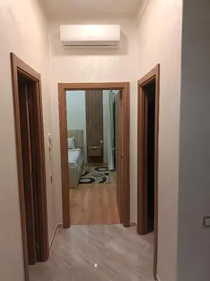 a hallway of a room with a bed and two doors at Oasis Appart in Marrakech