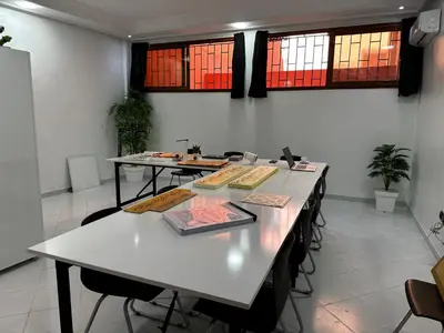 a room with tables with books on them and windows at Alouarcha in Marrakech