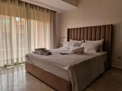 a bedroom with a large bed with a large window at Marrakech appartement babylon2 in Marrakech