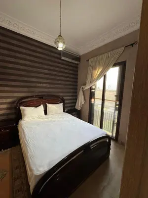 a bedroom with a bed and a large window at Appart 2ch Marrakech in Sraghna