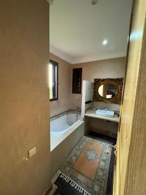 a bathroom with a tub and a sink and a mirror at Appart 2ch Marrakech in Sraghna