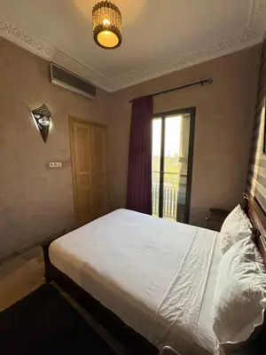 a bedroom with a large white bed with a window at Appart 2ch Marrakech in Sraghna