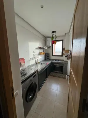 a small kitchen with a washer and dryer at Appart 2ch Marrakech in Sraghna