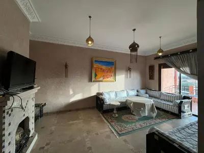 a living room with a couch and a fireplace at Appart 2ch Marrakech in Sraghna