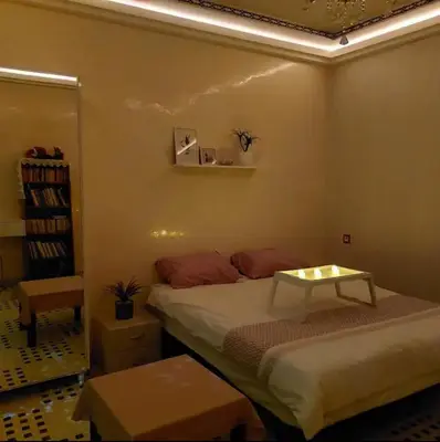 a bedroom with a bed with a table on it at The Red Flat in Marrakech