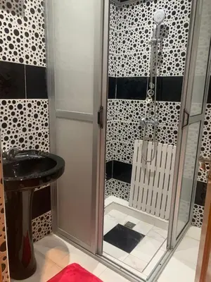 a bathroom with a shower with a glass door at The Red Flat in Marrakech
