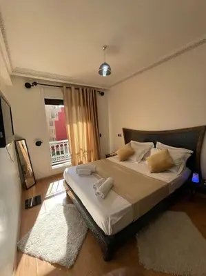 a bedroom with a large bed and a window at Guéliz appartemment Piscine à la résidence in Marrakech