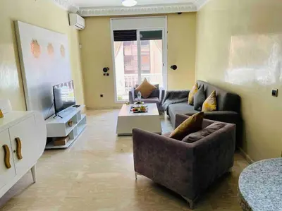 a living room with a couch and a tv at Guéliz appartemment Piscine à la résidence in Marrakech
