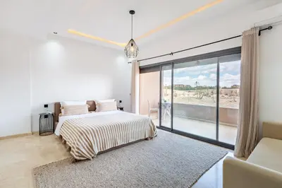 a bedroom with a bed and a large window at Villa Gina, chic et Moderne avec piscine&terrasse in Marrakech